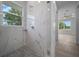 Modern shower with marble-look tile, mosaic floor, and window view at 1058 Se 59Th St, Ocala, FL 34480