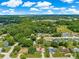 This aerial view captures a charming home in a tranquil neighborhood with lush greenery surrounding it at 10739 Se 44Th Ter, Belleview, FL 34420