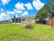 Expansive backyard featuring green lawn, patio, mature trees, and partial wood fence at 10739 Se 44Th Ter, Belleview, FL 34420