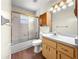 Bathroom featuring a white vanity, mirrored cabinet, and shower-tub with glass doors at 10739 Se 44Th Ter, Belleview, FL 34420