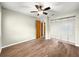 Bright bedroom features wood floors, ceiling fan, and mirrored closet at 10739 Se 44Th Ter, Belleview, FL 34420