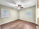 Vacant bedroom with wood-look floors, ceiling fan, and two windows at 10739 Se 44Th Ter, Belleview, FL 34420
