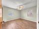 Bright bedroom with wood-look floors, ceiling fan, and two windows at 10739 Se 44Th Ter, Belleview, FL 34420