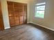 Bedroom featuring new wood floors, closet with bifold doors, and natural light at 10739 Se 44Th Ter, Belleview, FL 34420