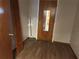 Hallway featuring new wood floors, closet with bifold doors, and doorway to kitchen at 10739 Se 44Th Ter, Belleview, FL 34420
