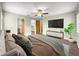 Main bedroom featuring wood floors, ceiling fan, and ensuite bathroom access at 10739 Se 44Th Ter, Belleview, FL 34420