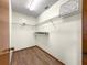 Walk-in closet featuring built-in shelving and wood floors at 10739 Se 44Th Ter, Belleview, FL 34420
