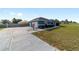 Side view of a blue single-story home featuring an attached garage and a long driveway at 13115 Sw 49Th Ave, Ocala, FL 34473