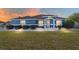 Charming blue single-story home with manicured landscaping, decorative rock, and an inviting entrance at sunset at 13115 Sw 49Th Ave, Ocala, FL 34473
