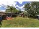 Spacious backyard featuring a screened-in pool area, lush lawn, and a charming playset, perfect for outdoor fun at 15 Sunrise Dr, Ocala, FL 34472
