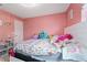 Cozy bedroom featuring pink walls, a comfortable bed, and bright accents for a playful atmosphere at 15 Sunrise Dr, Ocala, FL 34472
