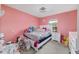 Bright pink bedroom with a white bed, window and lots of toys for a vibrant and cheerful space at 15 Sunrise Dr, Ocala, FL 34472