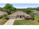 Aerial view of a single-story home featuring a manicured lawn, mature trees, and a private driveway at 15 Sunrise Dr, Ocala, FL 34472