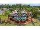 Backyard featuring a screened in pool, lush landscaping, and mature palm trees at 15 Sunrise Dr, Ocala, FL 34472