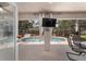 A screened-in pool area with outdoor seating and a television for entertainment and relaxation at 15 Sunrise Dr, Ocala, FL 34472