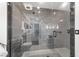 Modern bathroom shower featuring stylish gray tiling, rainfall shower head, and glass door at 15 Sunrise Dr, Ocala, FL 34472