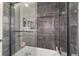 Modern bathroom shower featuring stylish gray tiling, glass door, and brushed metal fixtures at 15 Sunrise Dr, Ocala, FL 34472