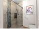 Bright bathroom with tiled shower, a glass door, a built-in soap niche, and a framed flamingo picture at 15825 Sw 11Th Court Rd, Ocala, FL 34473