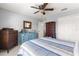 Spacious bedroom featuring neutral carpet and light gray walls with a ceiling fan and a blue dresser at 15825 Sw 11Th Court Rd, Ocala, FL 34473