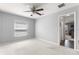 Minimalist bedroom featuring neutral carpet and light gray walls with a ceiling fan, and a window at 15825 Sw 11Th Court Rd, Ocala, FL 34473