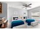 Bedroom with two beds featuring neutral carpet, ceiling fan and view of desk, and built-in shelving at 15825 Sw 11Th Court Rd, Ocala, FL 34473