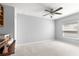 Spacious room featuring neutral carpet, light gray walls, ceiling fan, and a view of built-in shelving at 15825 Sw 11Th Court Rd, Ocala, FL 34473