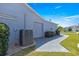 Side exterior of home, featuring a gray brick walkway, landscaping, and a view of the attached garage at 15825 Sw 11Th Court Rd, Ocala, FL 34473
