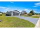 Charming home featuring a well-manicured lawn, gray brick driveway, and an attached garage for easy access at 15825 Sw 11Th Court Rd, Ocala, FL 34473
