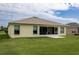 Rear exterior of home with screened in patio and large manicured lawn at 1690 Sw 158Th Ln, Ocala, FL 34473