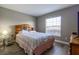 Cozy bedroom featuring a wooden headboard and ample natural light from a window at 1690 Sw 158Th Ln, Ocala, FL 34473
