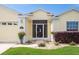 Close up of the front entrance, featuring a decorative security door, manicured lawn and mature shrubs at 1690 Sw 158Th Ln, Ocala, FL 34473