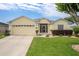 Charming yellow single-story home with a well-manicured lawn and attached two car garage at 1690 Sw 158Th Ln, Ocala, FL 34473