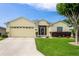 Charming yellow single-story home with a well-manicured lawn and attached two car garage at 1690 Sw 158Th Ln, Ocala, FL 34473