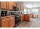 Open kitchen design features black appliances, wood cabinets and a breakfast nook with backyard views at 1690 Sw 158Th Ln, Ocala, FL 34473