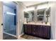 Main bathroom boasts double sinks, large mirrors, and a tiled walk-in shower with glass door at 1690 Sw 158Th Ln, Ocala, FL 34473