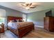 Comfortable main bedroom features a ceiling fan, dresser, and a large decorative wood bed at 1690 Sw 158Th Ln, Ocala, FL 34473