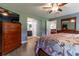 Spacious main bedroom boasts a ceiling fan, dresser, decorative bed and en-suite bathroom at 1690 Sw 158Th Ln, Ocala, FL 34473