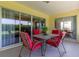 Covered patio with tile flooring, red cushioned seating, and view of back yard at 1690 Sw 158Th Ln, Ocala, FL 34473