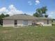 View of the back of the home with sliding glass doors and a spacious lawn at 1754 Sw 160Th Pl, Ocala, FL 34473