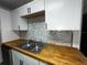 Updated kitchen with butcher block countertops, stainless steel sink, and neutral tile backsplash at 1809 Sw 29Th Ter, Ocala, FL 34474