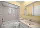 Bathroom with white tiled shower, vanity, neutral walls and window, providing a clean and functional space at 2158 Nw 50Th Ave, Ocala, FL 34482