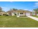Charming yellow home with brick accents, attached garage, and well-maintained lawn at 2158 Nw 50Th Ave, Ocala, FL 34482