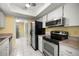 Well-equipped kitchen with stainless steel appliances, white cabinetry, and a view into the laundry area at 2158 Nw 50Th Ave, Ocala, FL 34482