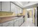 Kitchen featuring stainless steel appliances, white cabinets, tiled floor, and a view into the laundry area at 2158 Nw 50Th Ave, Ocala, FL 34482