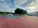 Community tennis court with green and red surface, complete with benches and netting at 2158 Nw 50Th Ave, Ocala, FL 34482