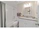Bathroom features granite countertop vanity, white cabinets, and a shower-tub combination with a gray curtain at 2220 Ne 41St St, Ocala, FL 34479