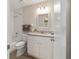 Bathroom with granite countertop vanity, white cabinets, framed mirror, and tiled shower and tub at 2220 Ne 41St St, Ocala, FL 34479
