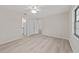 Bright bedroom with modern ceiling fan, light gray wood flooring, and ensuite bathroom access at 2220 Ne 41St St, Ocala, FL 34479
