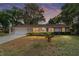 Charming single-story home with a well-manicured lawn and mature trees at sunset at 2220 Ne 41St St, Ocala, FL 34479