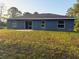Backyard with a grassy lawn and exterior view of the home at 227 Fisher Run, Ocklawaha, FL 32179